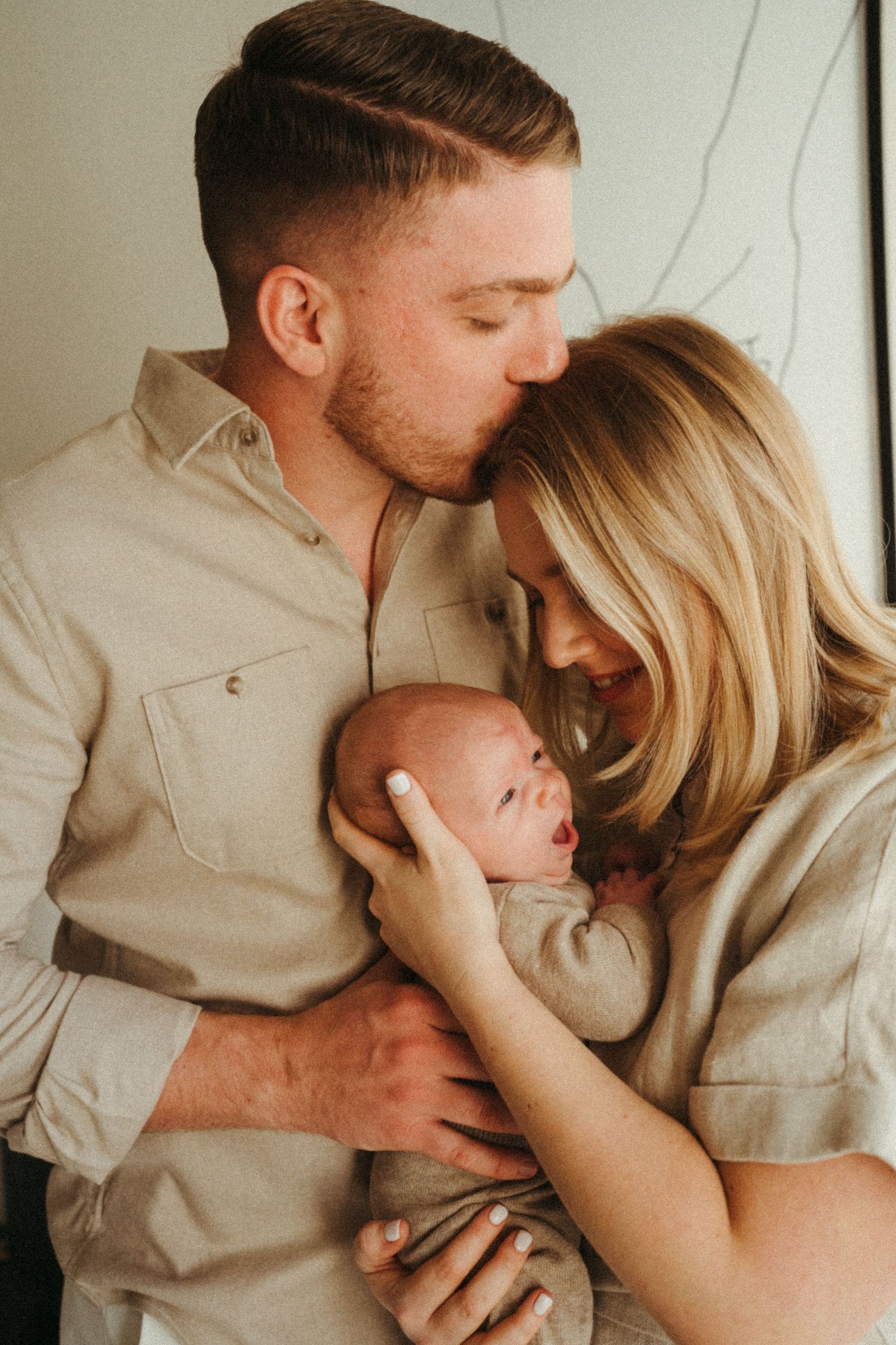 Intimate family moment captured in black and white showing tender affection and closeness.