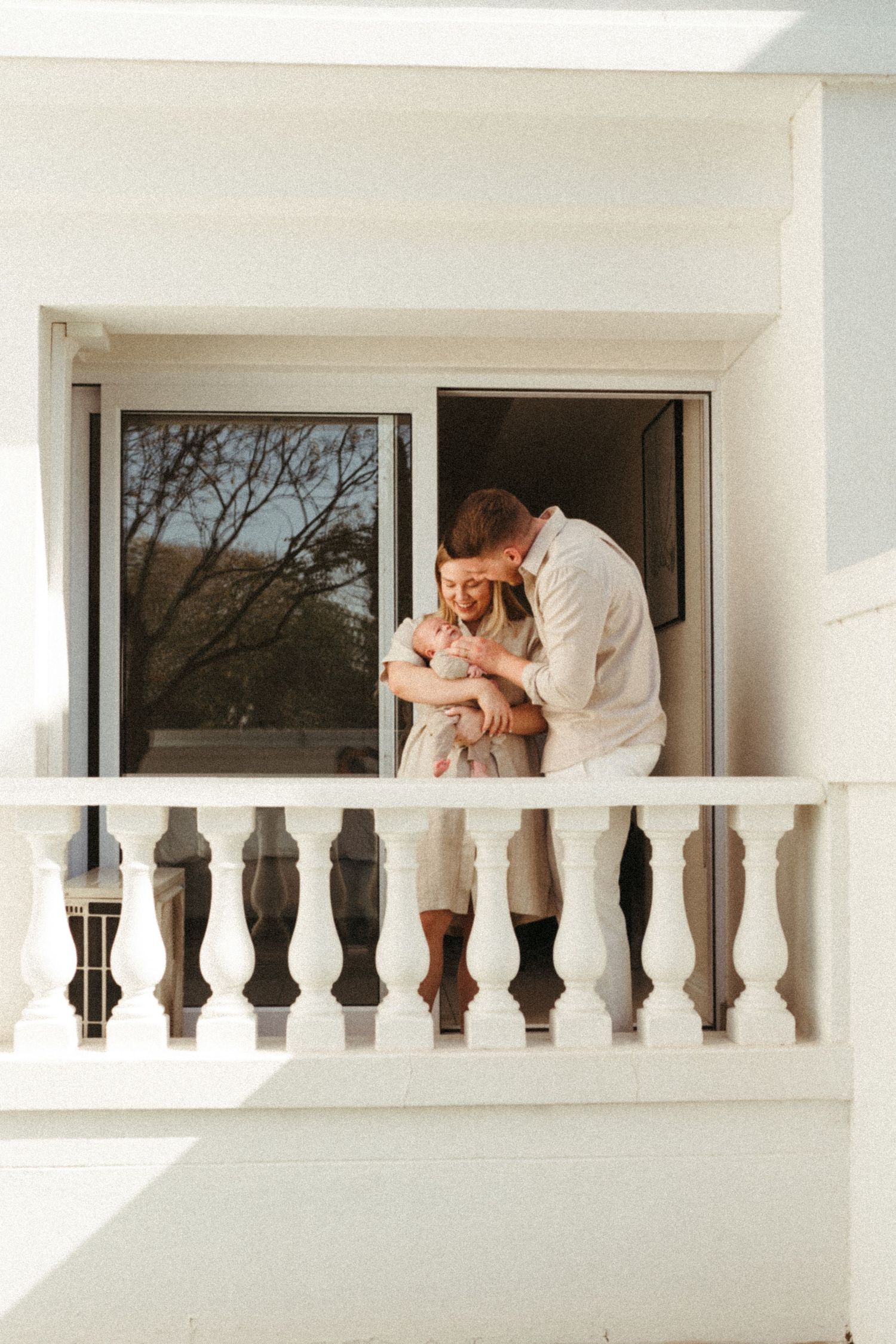 A series of romantic poses captured on a white colonial-style balcony with ornate railings.