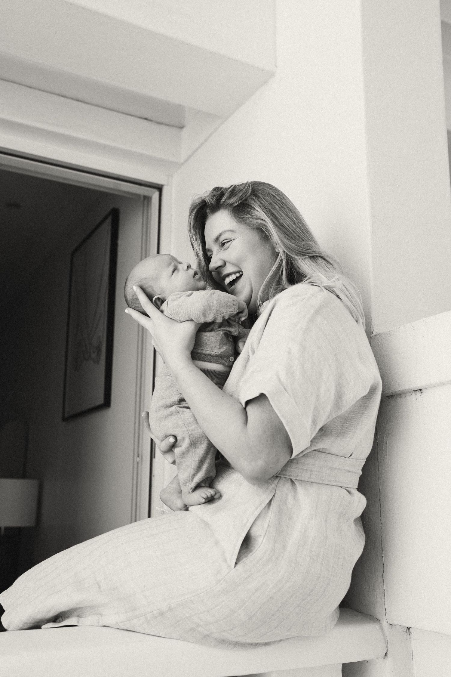 Black and white photo of intimate bonding moment with newborn.