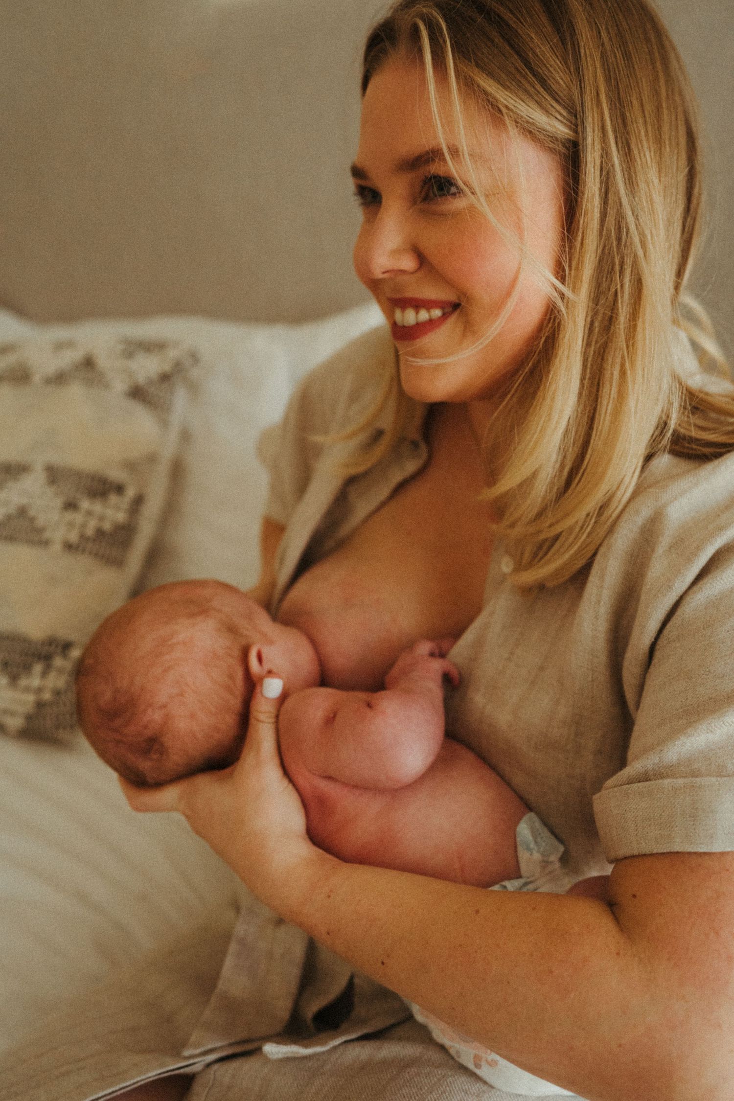 Intimate newborn photography session on white bedding.