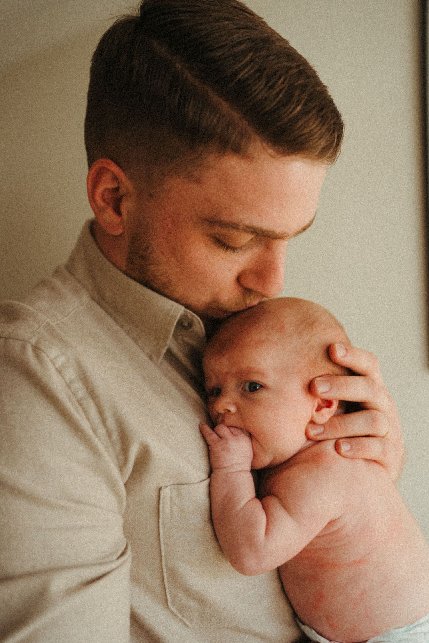 A tender moment captured in a series of intimate black and white photographs showing gentle interaction with a newborn.