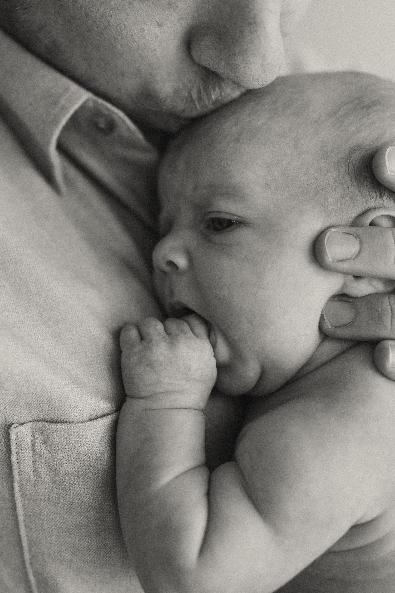 Intimate black and white series showing gentle moments with a newborn baby.