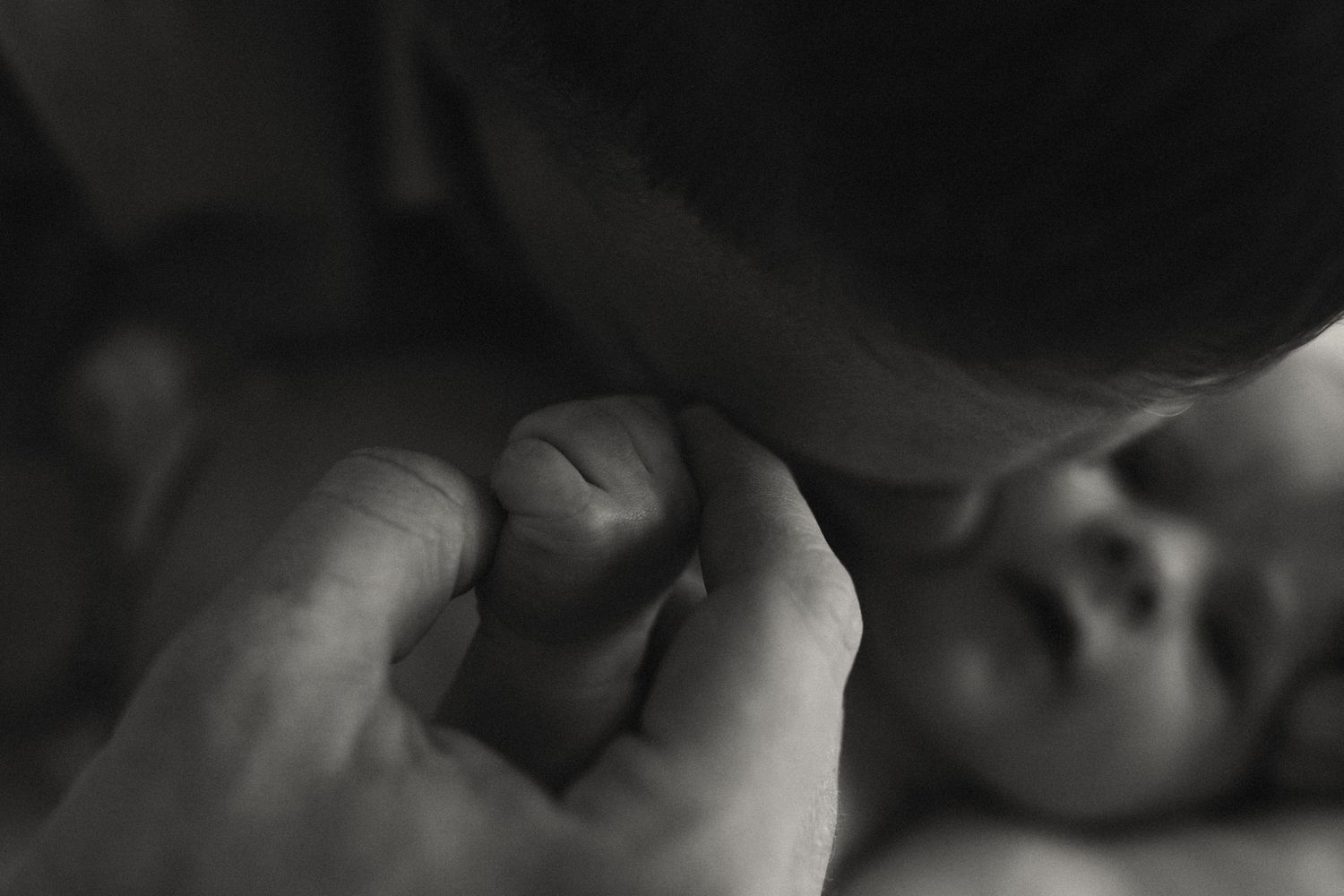 Dramatic black and white close-up of a sleeping newborn's features.