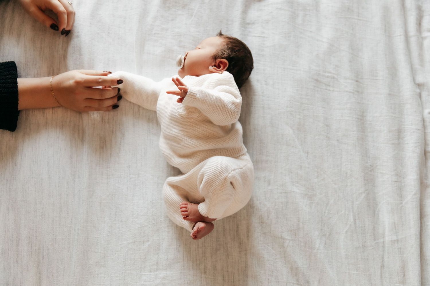 Documentary family photo of a newborn baby and her mother's hand at their home in Minneapolis, MN.