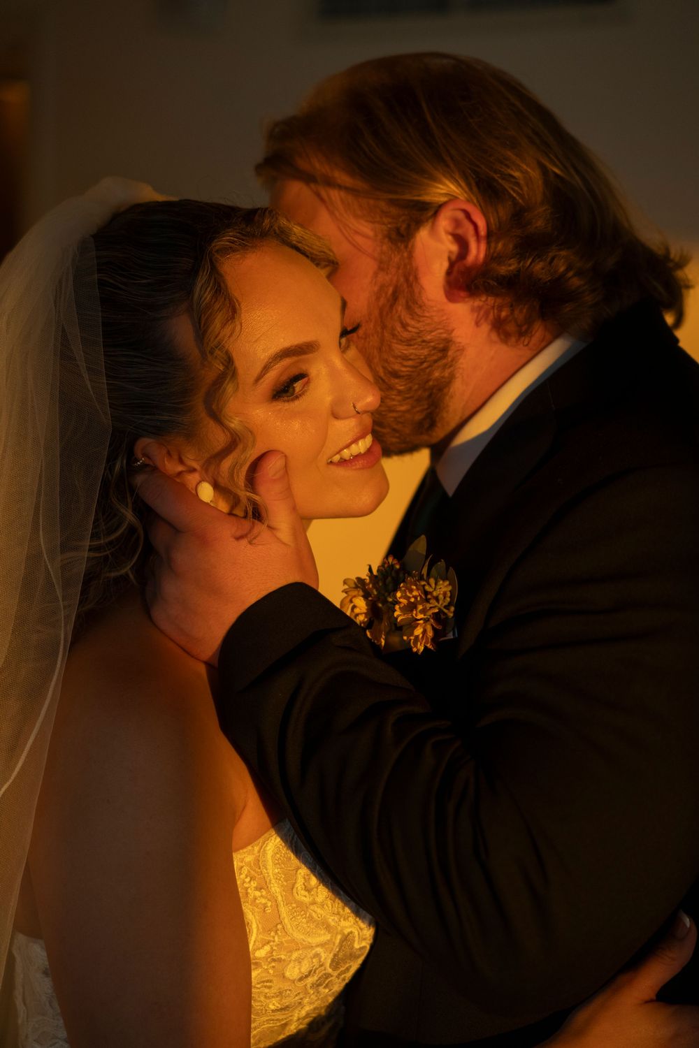 Intimate wedding portrait silhouetted against warm golden lighting.