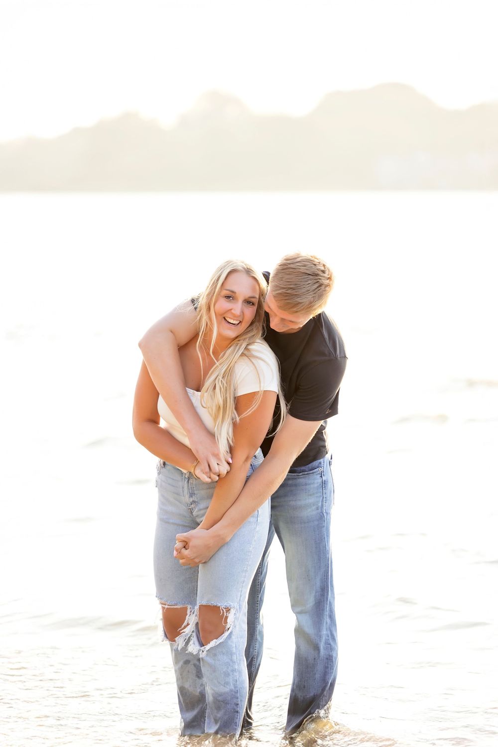 Couple sharing intimate moments together at the beach during golden hour.