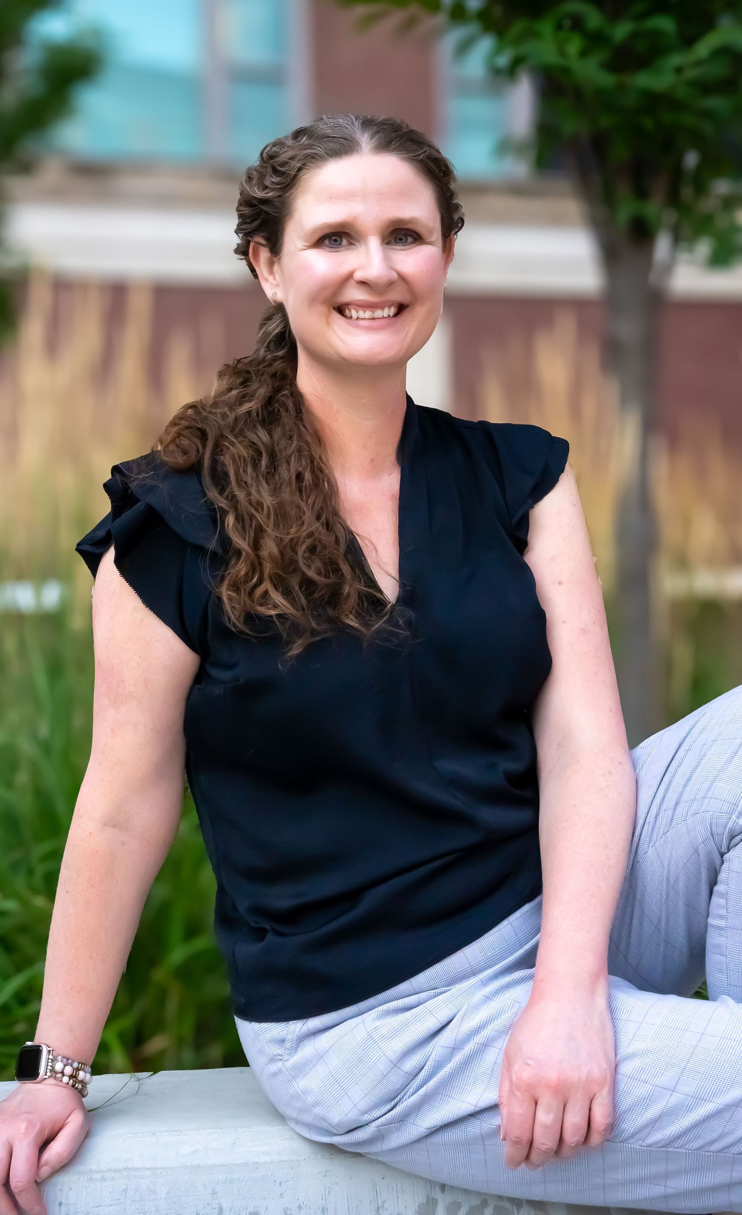 Professional portrait series showing relaxed casual pose against outdoor backdrop.