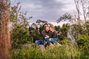 A romantic outdoor portrait in a meadow with soft evening light and natural surroundings.