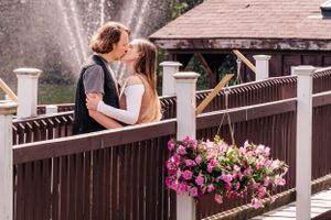 A tender embrace on a deck railing decorated with pink and white flowers.