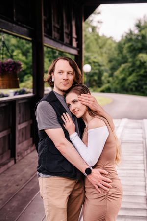 A couple sharing an intimate moment on a covered wooden deck.