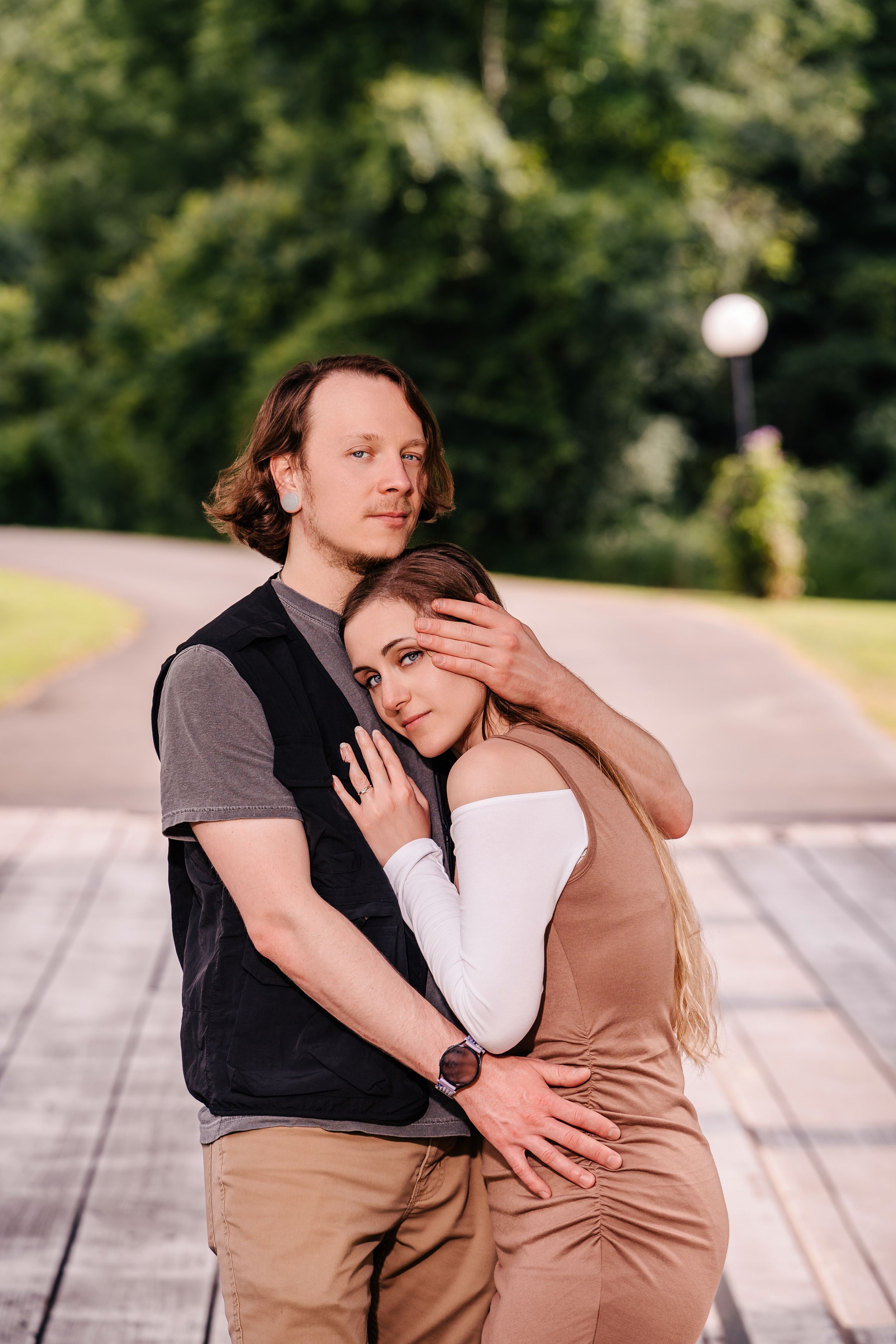 A tender embrace shared on a wooden deck with a garden backdrop.