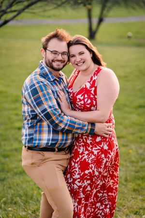 A joyful outdoor portrait of a couple embracing in matching casual spring outfits.