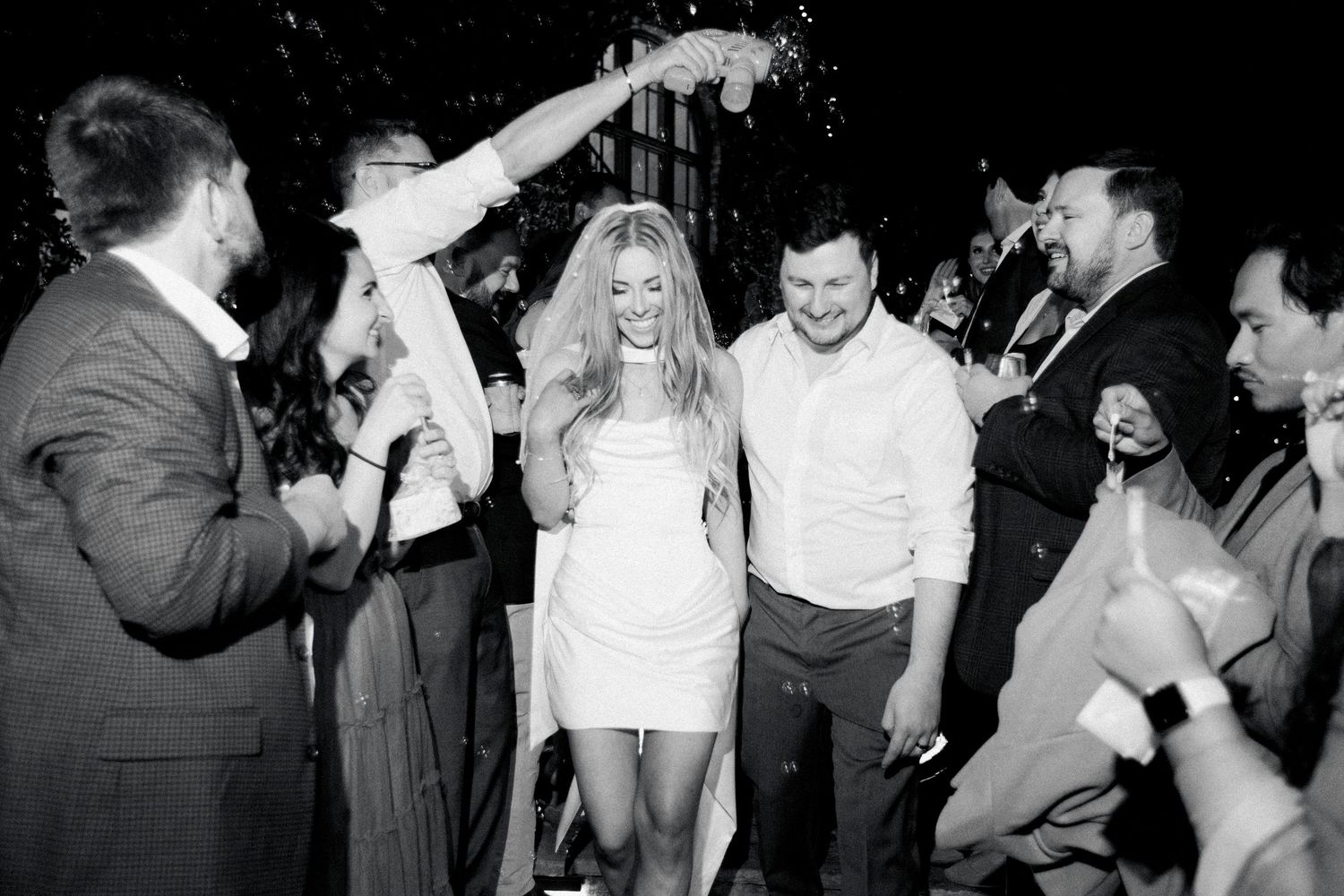 photo of a bride and groom running through bubbles during the grand exit at a wedding at Montaluce Winery in Dahlonega Georgia.