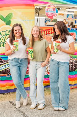 Three senior girls posing with drinks at the fair in Newnan GA, unique senior portrait