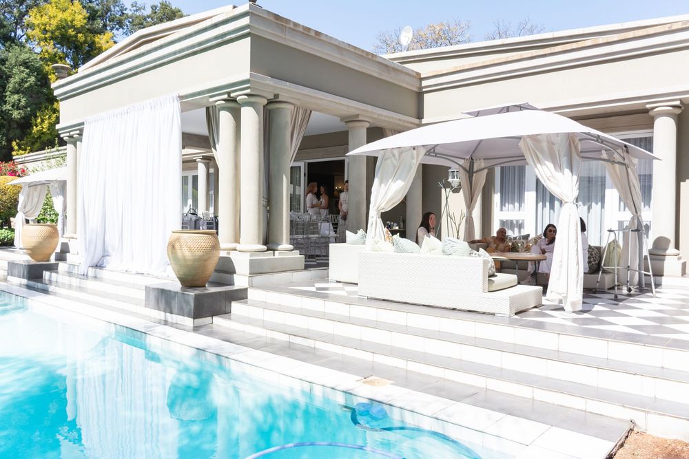 Luxurious white villa with modern outdoor lounge areas and infinity pool overlooking scenic landscape views.