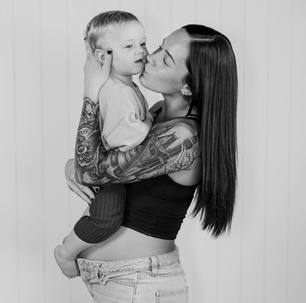 A series of black and white photos showing tender moments between a parent and baby in casual attire.