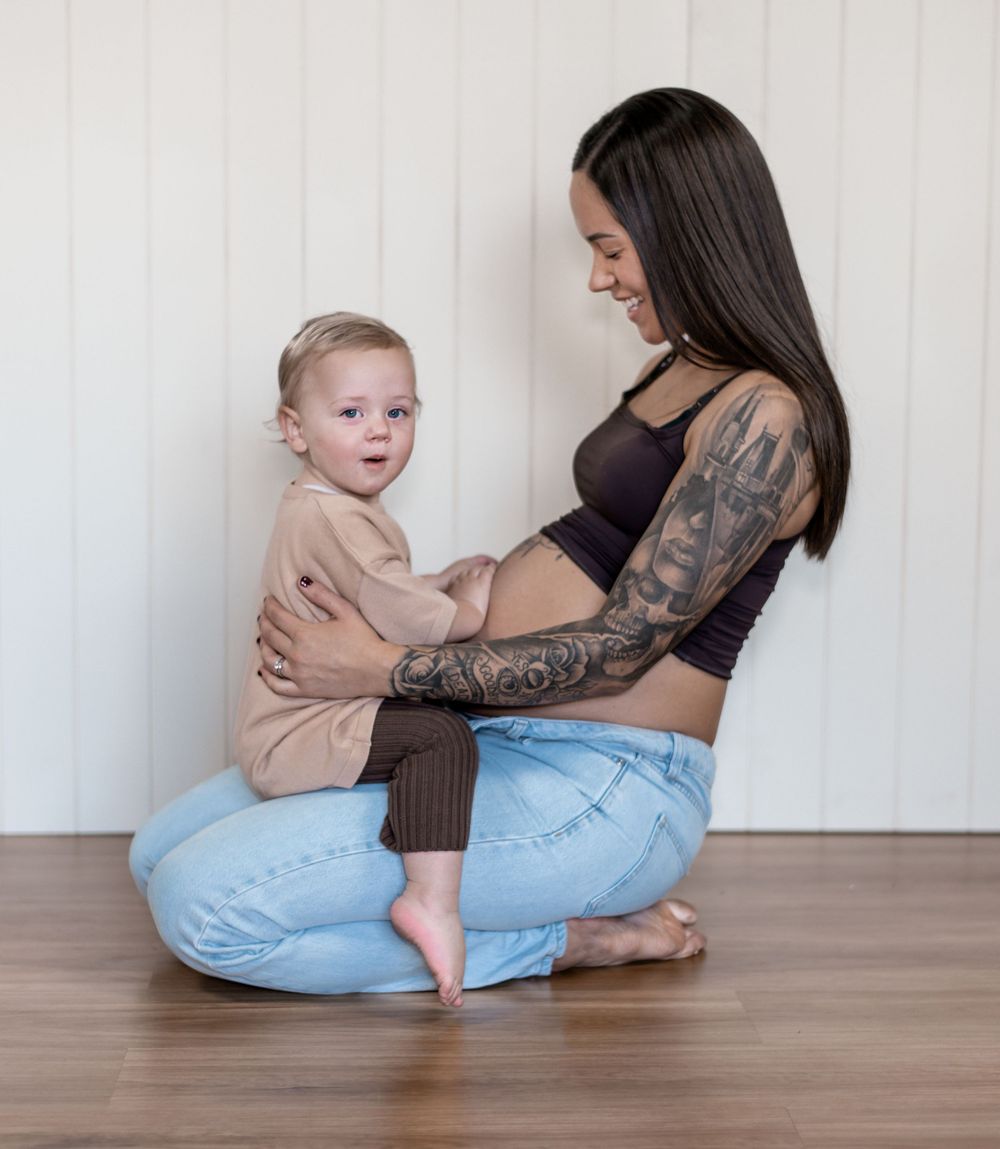 A parent in jeans and black top sits on hardwood floor with a baby in a series of progressive interaction shots.
