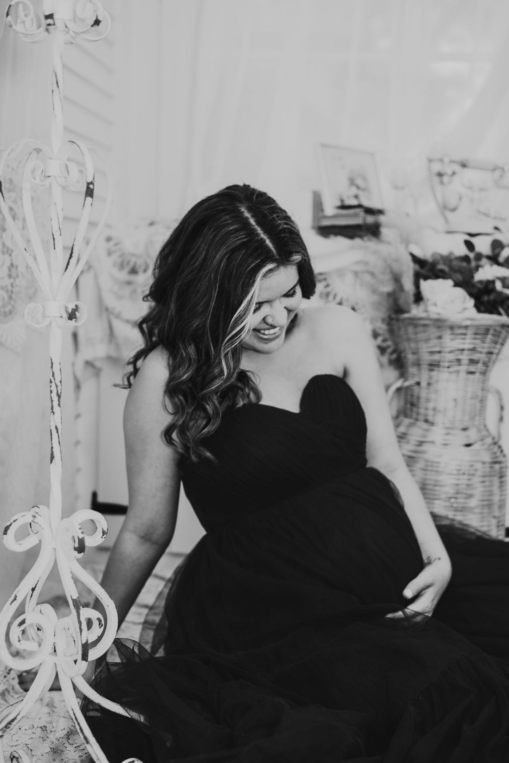 Expecting mother in black and white shot of her cradling her baby bump