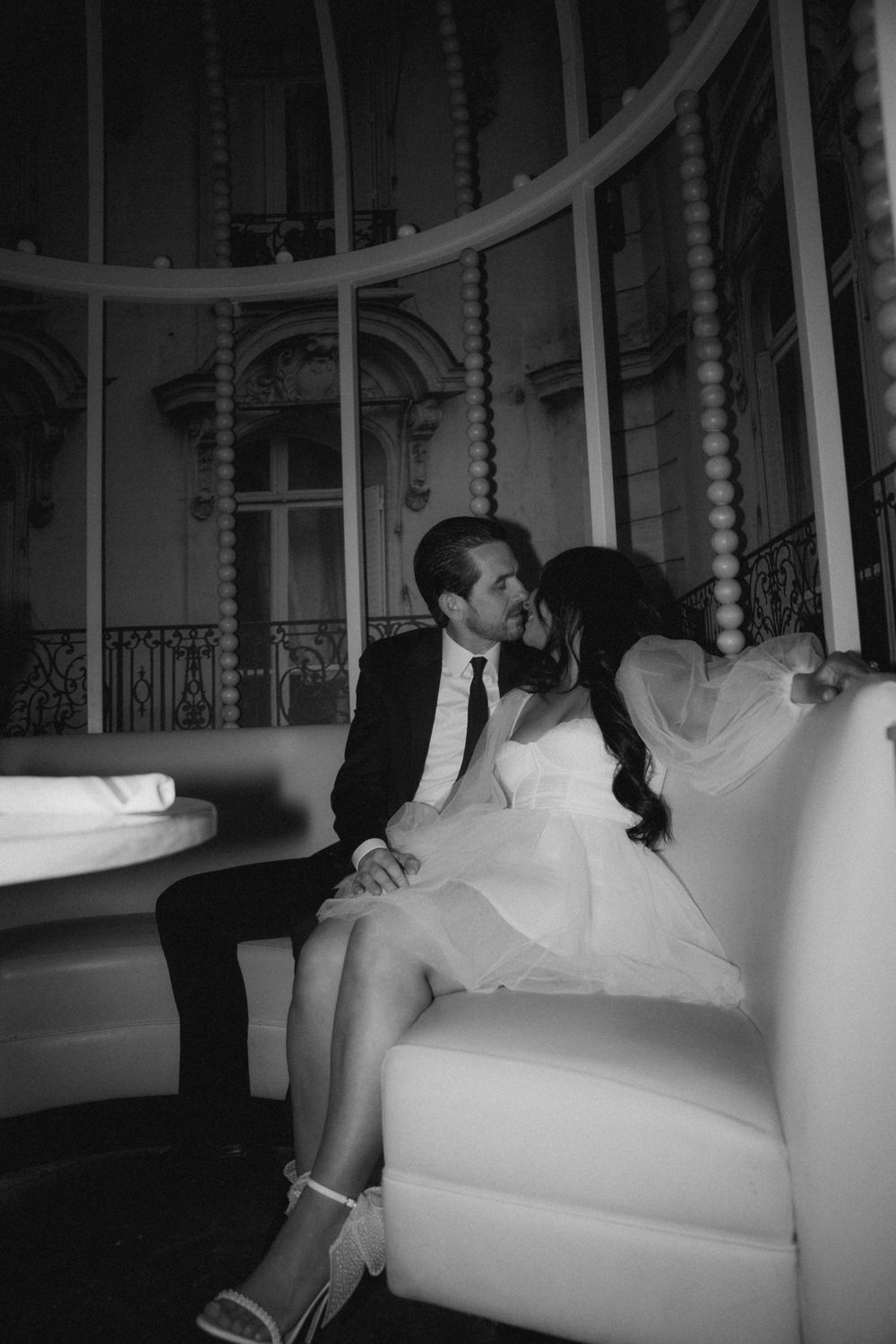 A romantic couple shares an intimate moment on an elegant white couch.