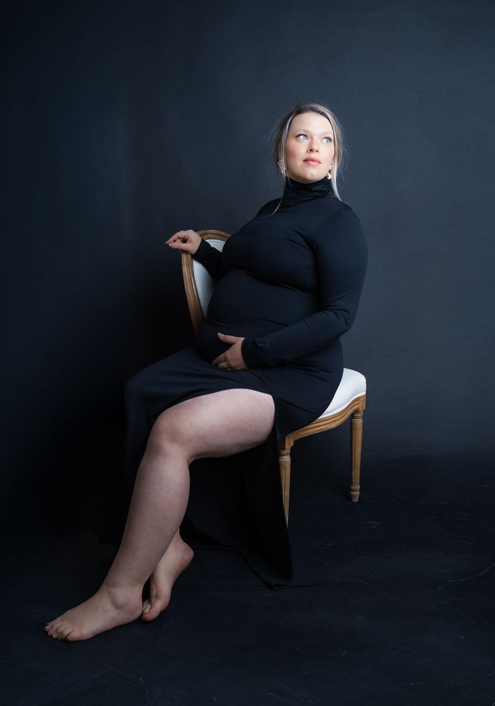 Artistic black and white photo series showing a figure in black dress seated on wooden chair against dark backdrop.
