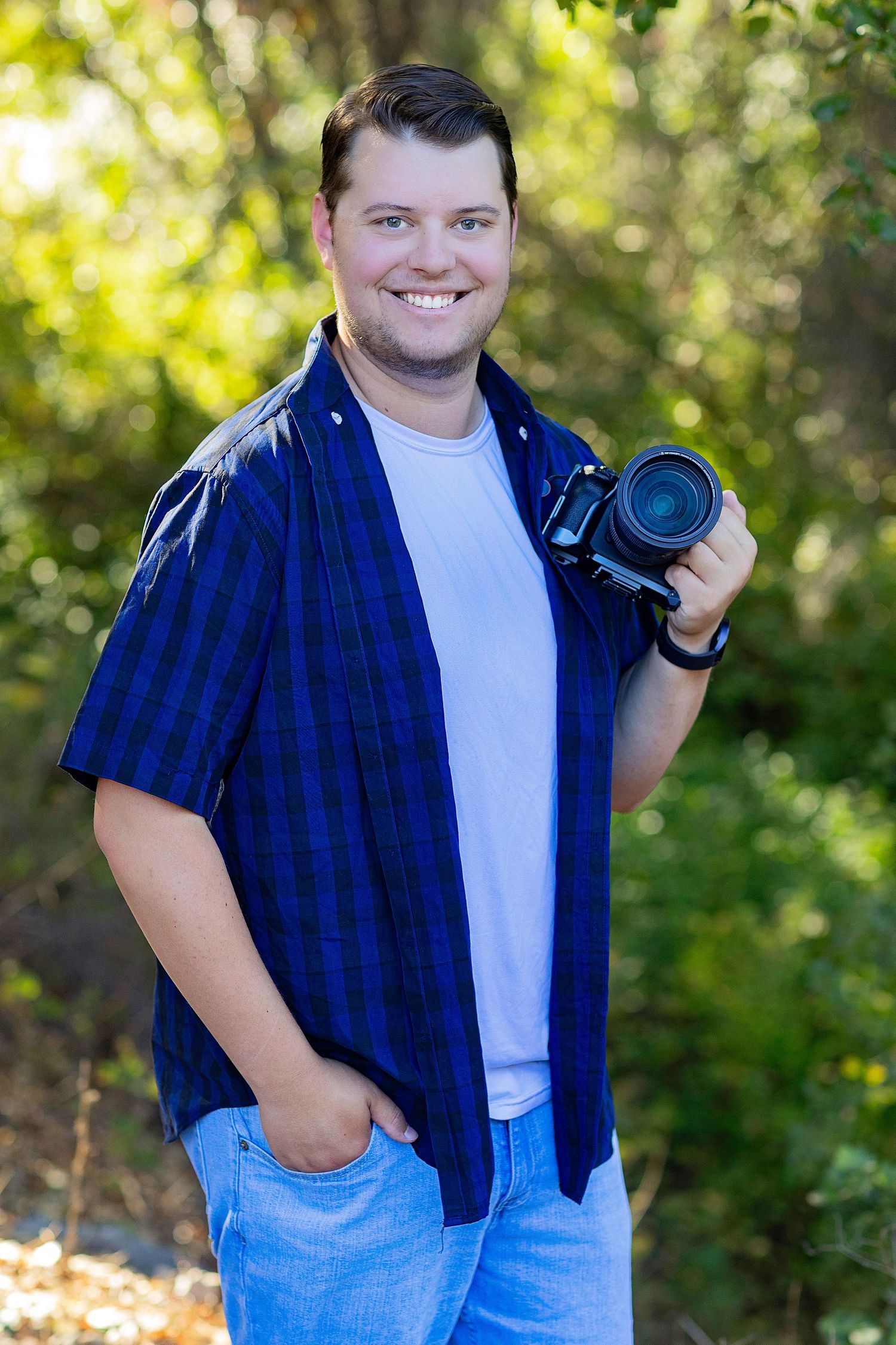 A photographer in a floral print white shirt captures a photo with a professional DSLR camera.