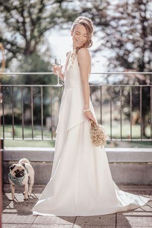 A flowing white wedding dress photographed in sections against a stone railing with cherry blossoms in the background.