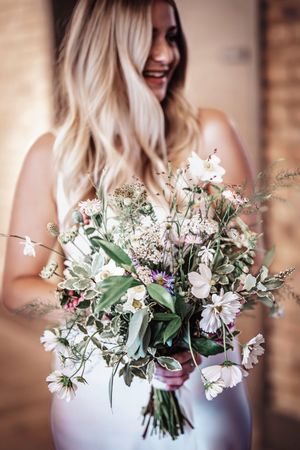 Delicate pastel wedding bouquets with white flowers and greenery displayed in a series.