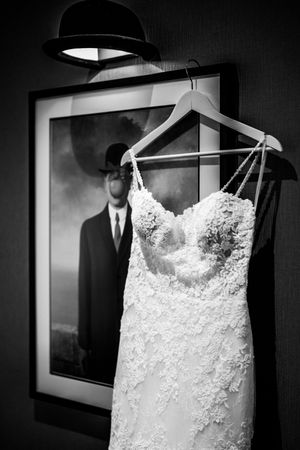 A sequence of black and white photos showing an elegant white lace wedding dress hanging on display.