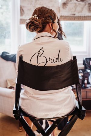 A series of director's chairs with 'Bride' written in elegant script on the white fabric backs.