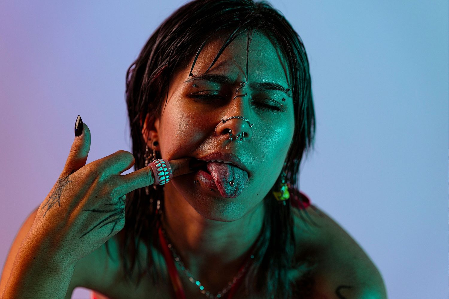 Close-up portrait with dramatic blue and red lighting creating a moody atmosphere.