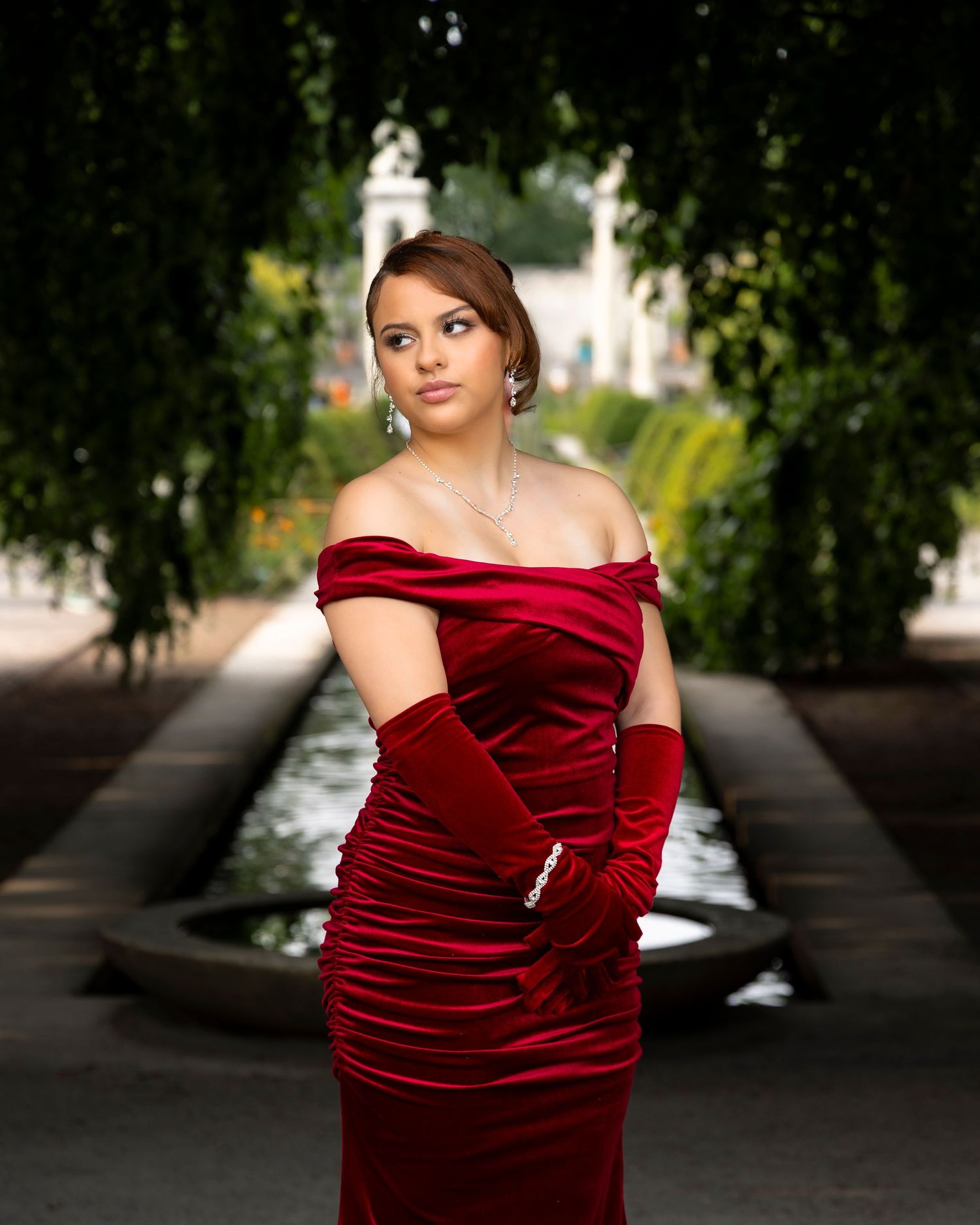 Woman in yellow dress poses with basket in sunflower field during golden hour.