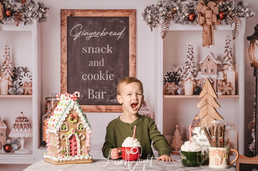 Child at gingerbread cookie bar display with holiday decorations and excited expression.