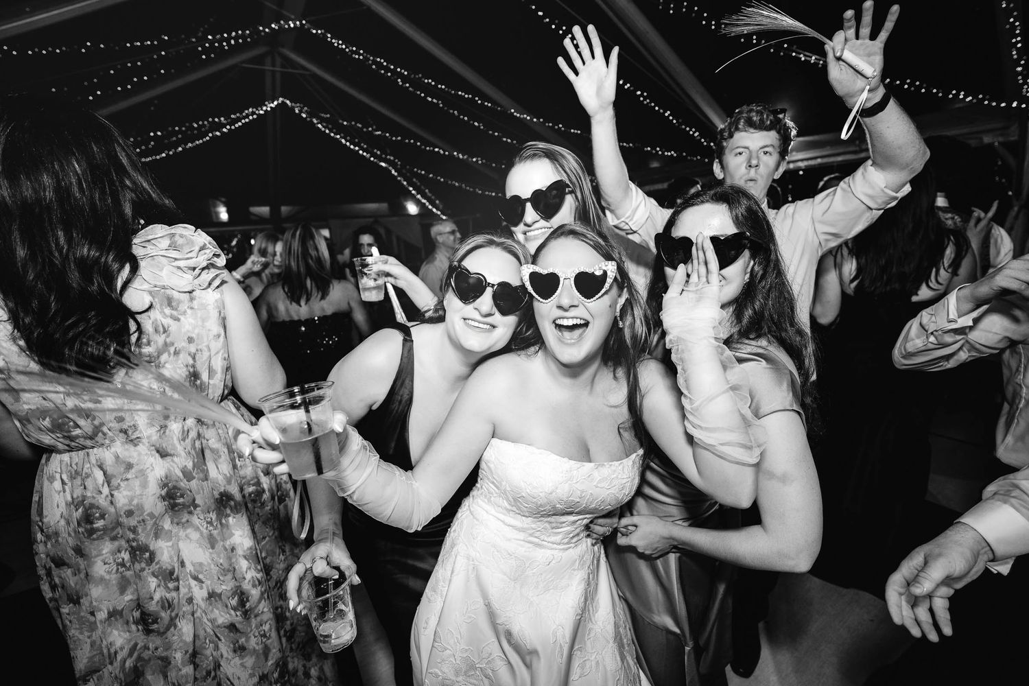 Bride and her friends in heart sunglasses celebrating on the dance floor at a Treasure Coast wedding reception