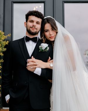 Newlywed couple in formal wedding attire sharing intimate moments while checking their phones together.