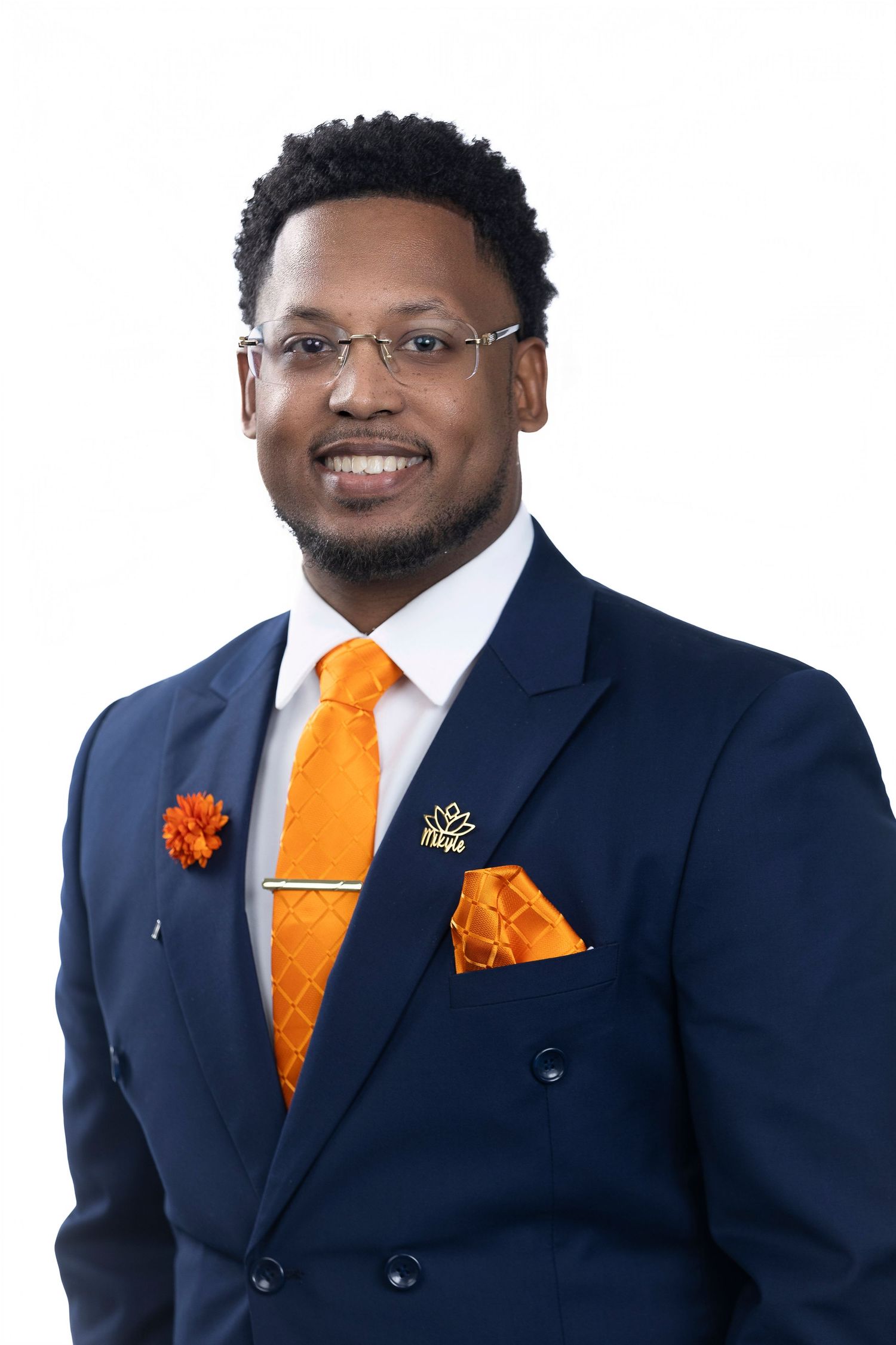 Professional headshots of man in navy suit with orange tie and pocket square.
