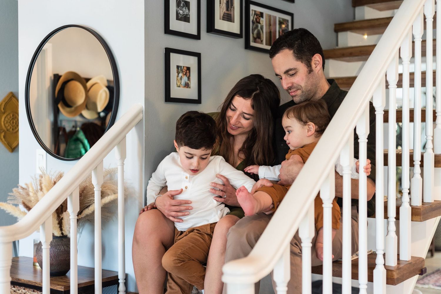 Family sharing a cozy moment while sitting together on carpeted stairs.