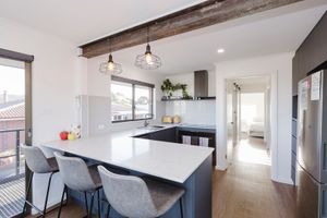 Modern open concept apartment interior with white walls and hardwood floors features minimalist design and natural lighting.