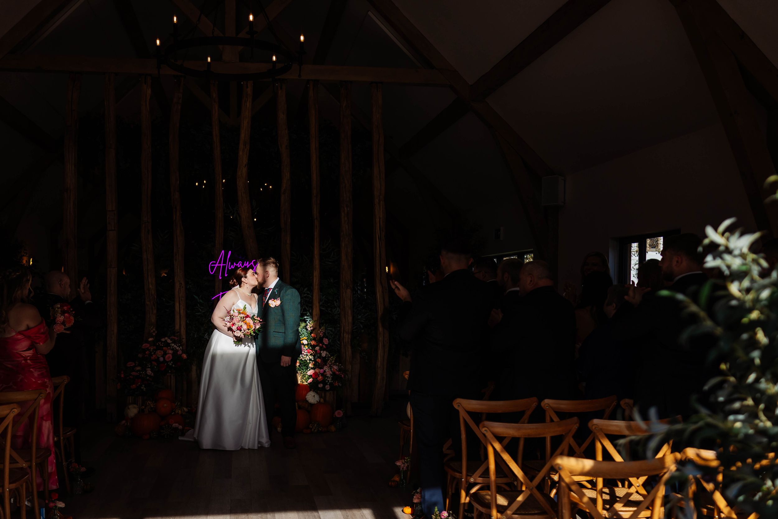 Bride & Groom share first kiss in spotlight during ceremony at The River Barn, Poulton le Fylde captured by Lynette Matthews Photography