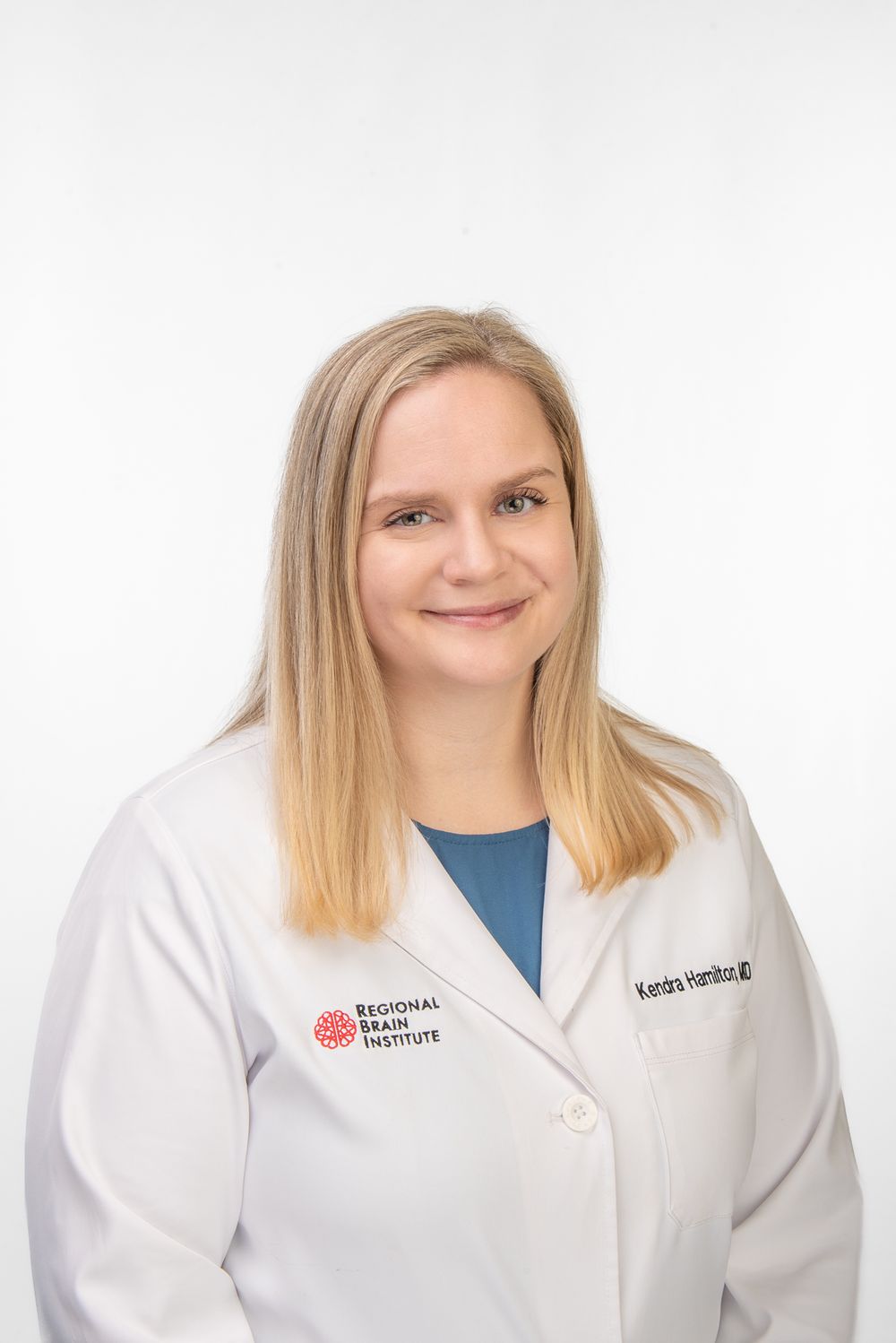 Business headshot of a white, blonde haired, Memphis woman in doctor's coat with white background.