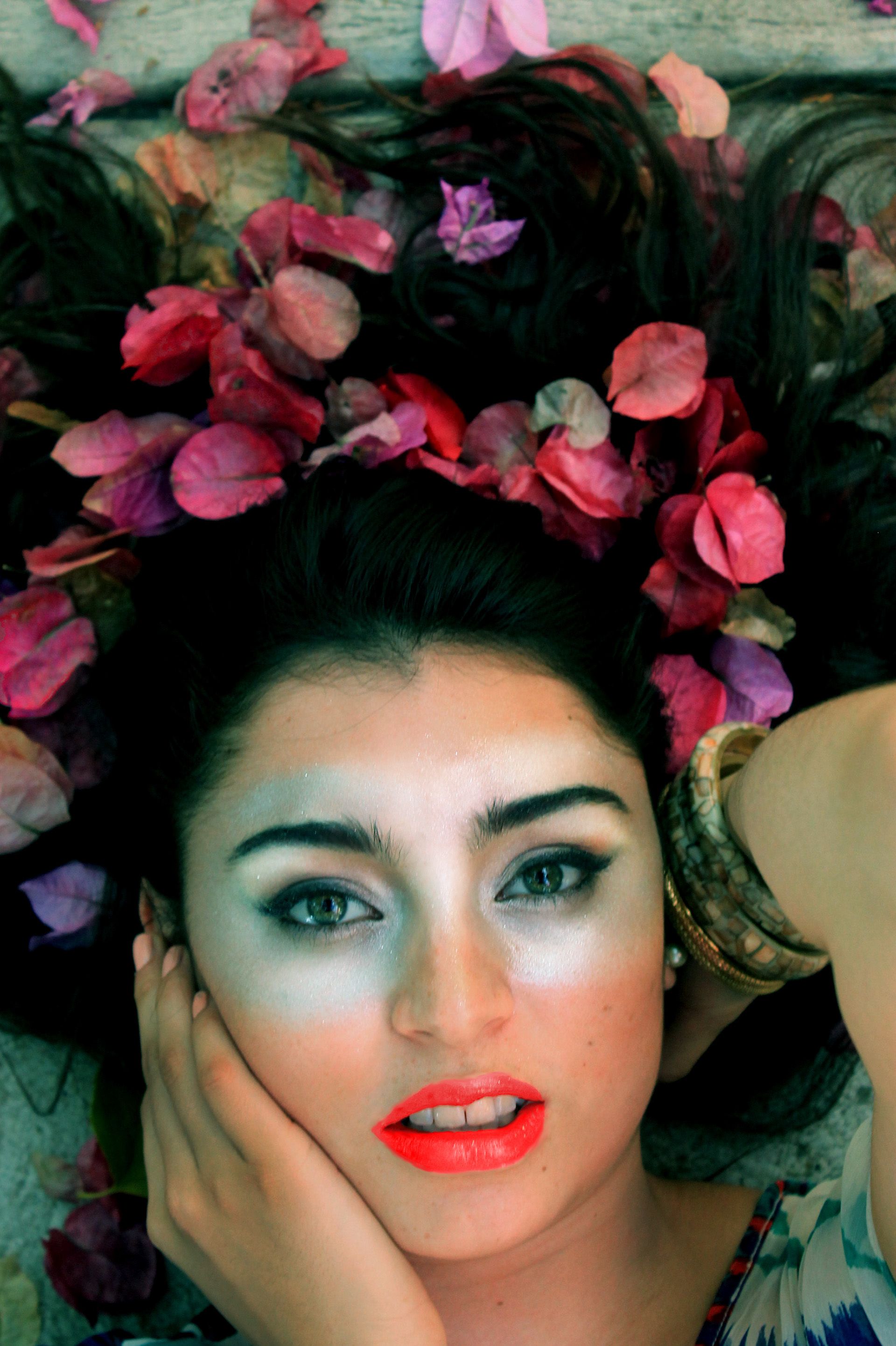 Artistic beauty portrait with pink and purple flowers creating a floral crown effect.