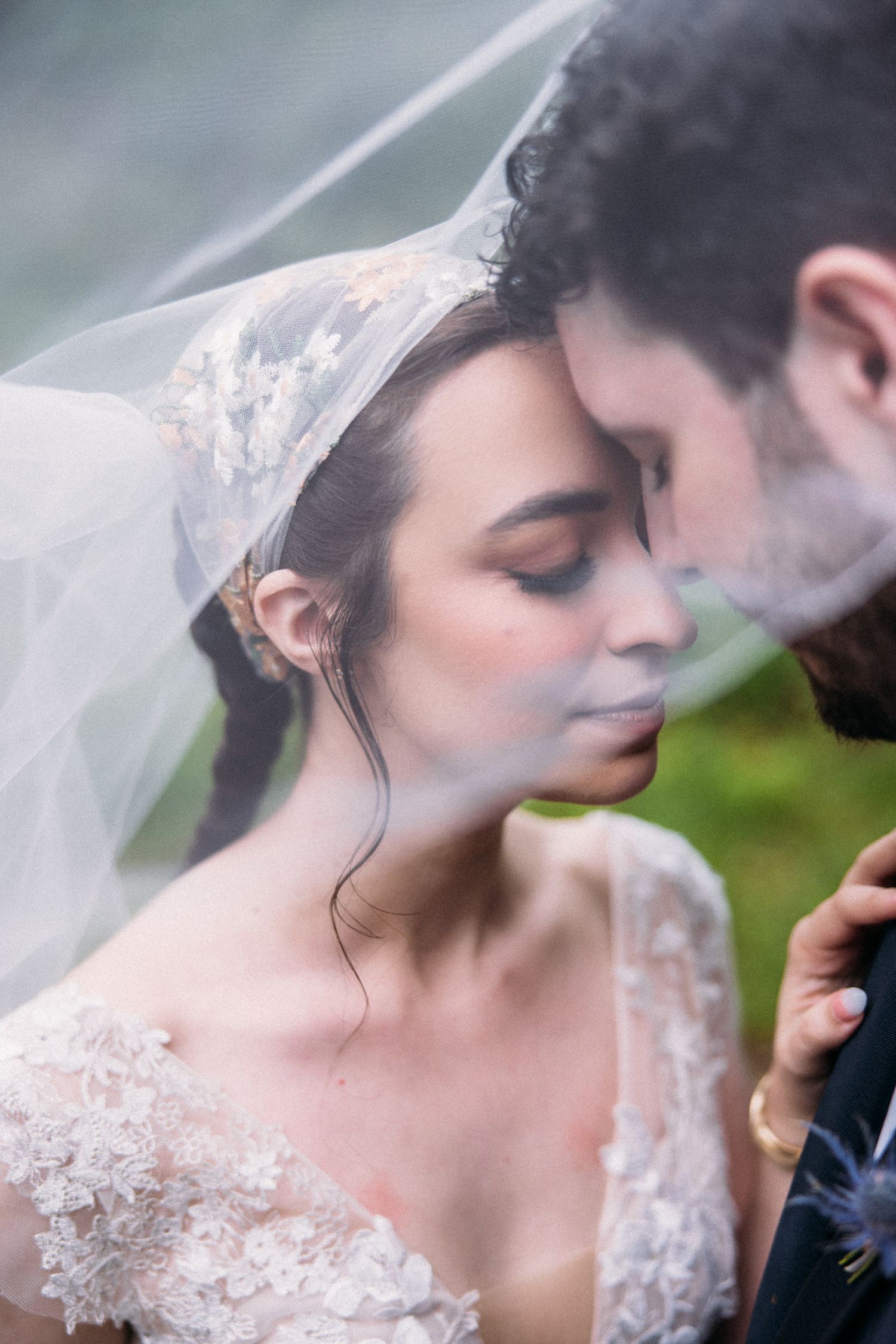 Romantic close-up of bride and groom sharing an intimate moment under a delicate veil.