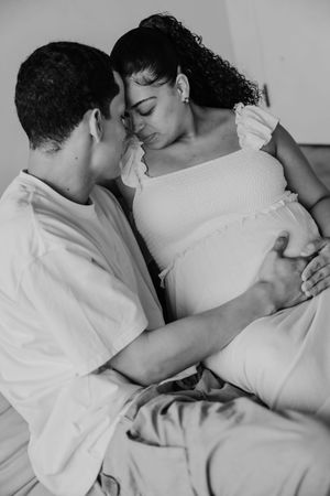 A black and white photo series shows two people embracing intimately while lying down together.