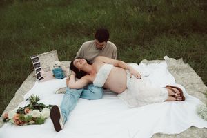 A romantic photoshoot series showing a person in a flowing white dress lying gracefully in an outdoor setting.