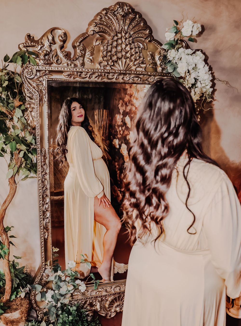 Ethereal bridal portrait with ornate mirror and floral decorations.