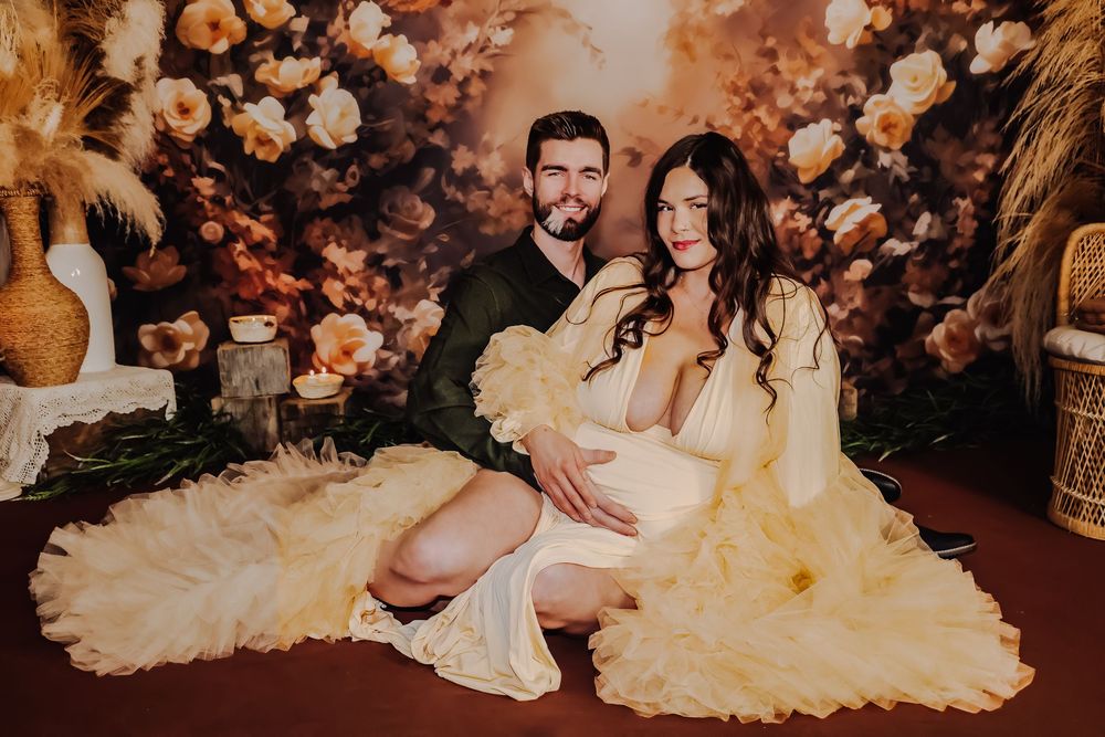 Romantic wedding photos with couple against floral backdrop in warm tones.
