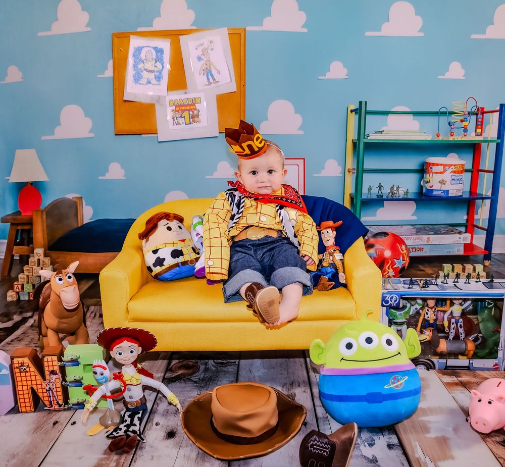 Toy Story themed nursery room with yellow couch and cloud wallpaper design.