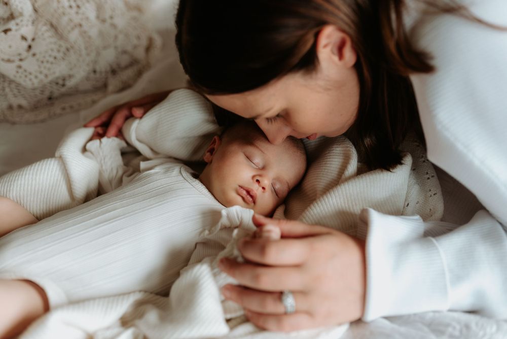 Intimate nurturing moment captured in soft monochromatic tones.