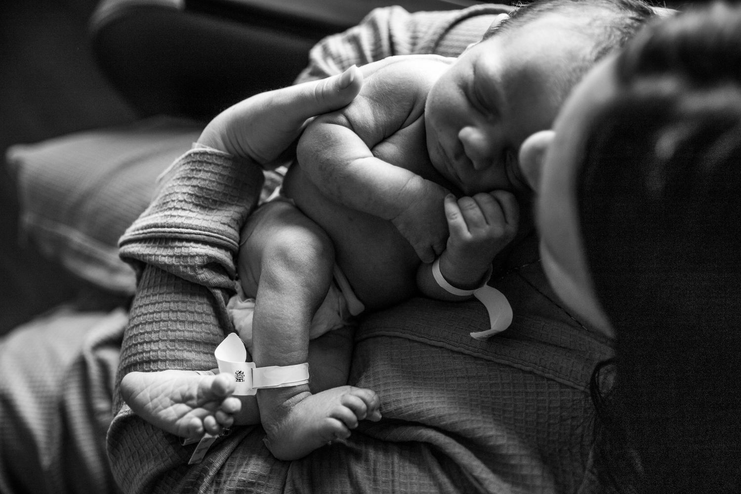 Newborn baby sleeping peacefully in black and white photography.