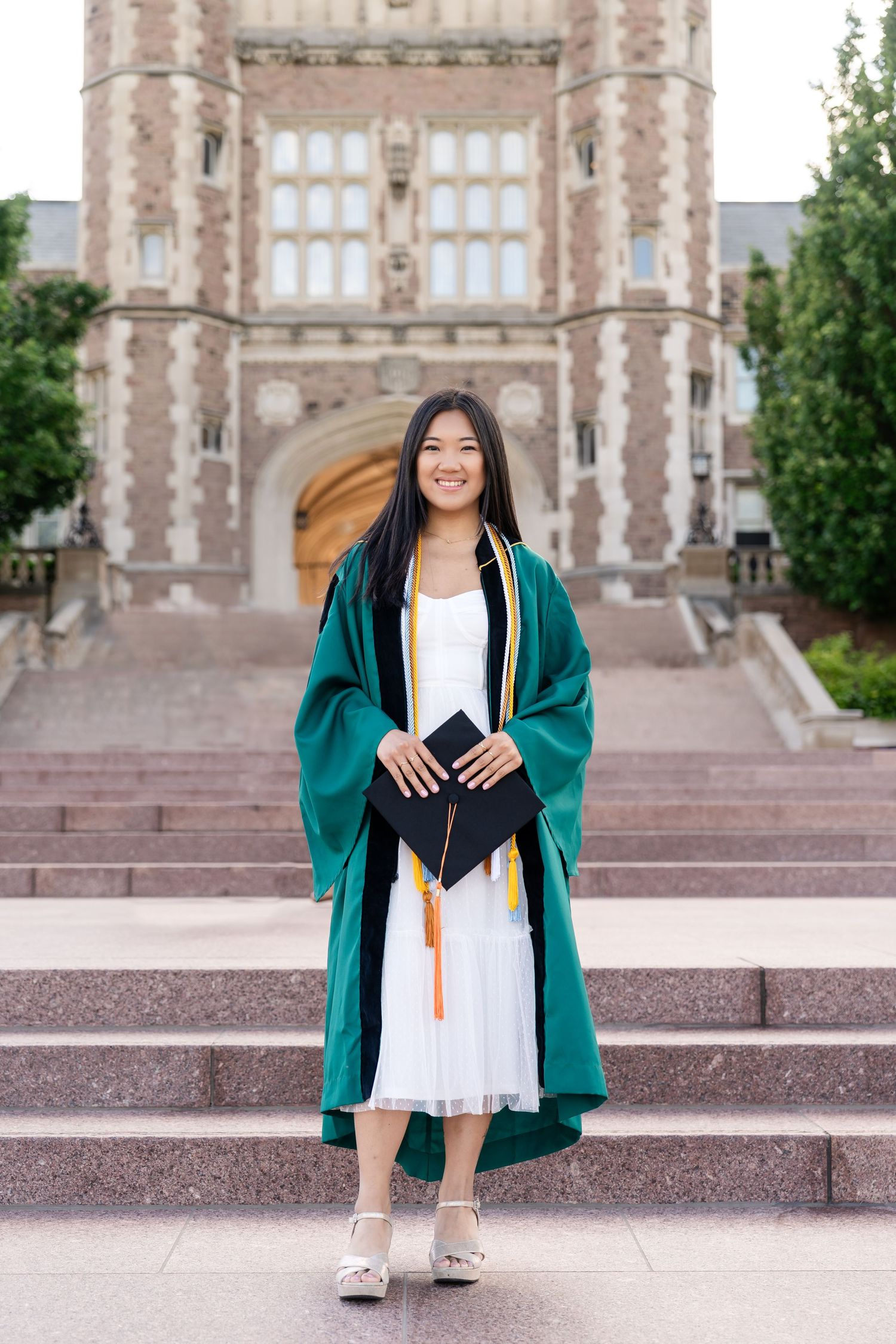Graduation photo of young girl smiling in green graduation gown, shot by Milwaukee event photographer Rachel Dickman.