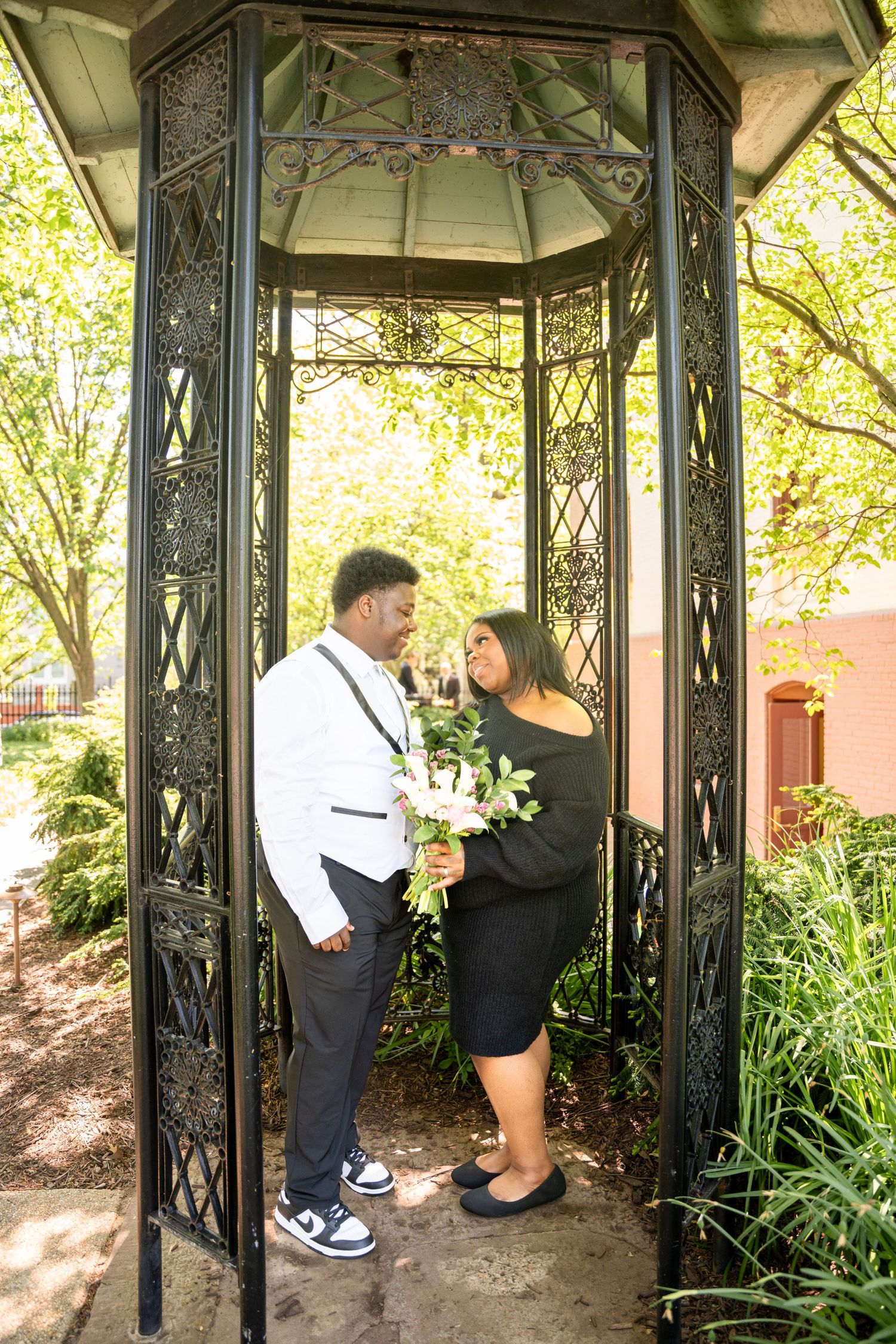 A series of four connected images showing a couple posing in an ornate gazebo structure in a garden setting.